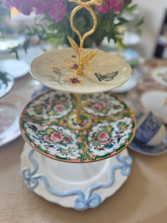 Three-tier serving stand with Lenox Butterfly Meadow plate on top, Famille Rose china in the middle, and Anthropologie bow plate on the bottom, gold hardware, all new plates.