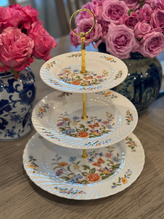 Three-tiered stand made from vintage Aynsley Cottage Garden plates with floral pattern and gold handle, styled on wooden table with pink roses