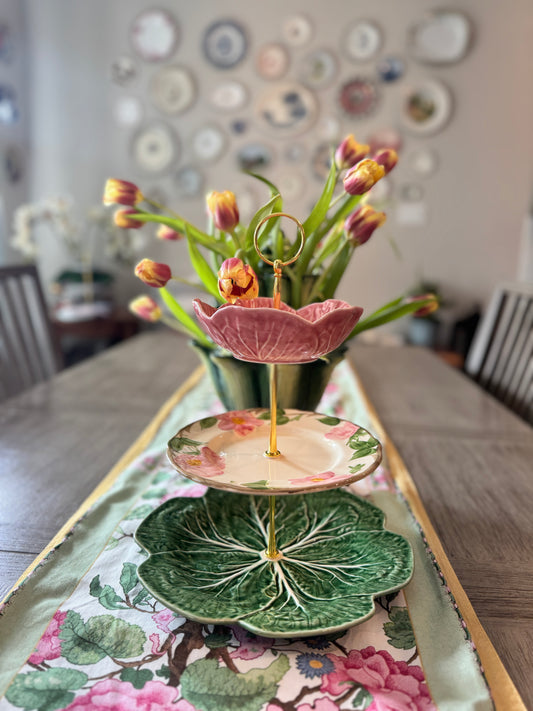 Colorful three-tiered vintage plate stand with pink cabbage bowl, floral dessert plate, and green cabbage charger